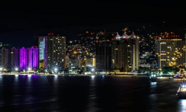 A breathtaking aerial view of Acapulco's illuminated skyline at night.