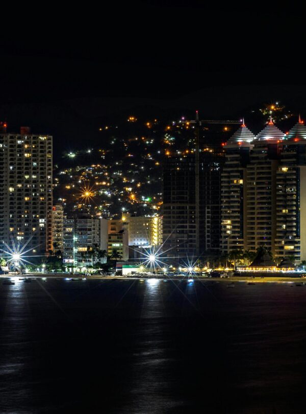 A breathtaking aerial view of Acapulco's illuminated skyline at night.