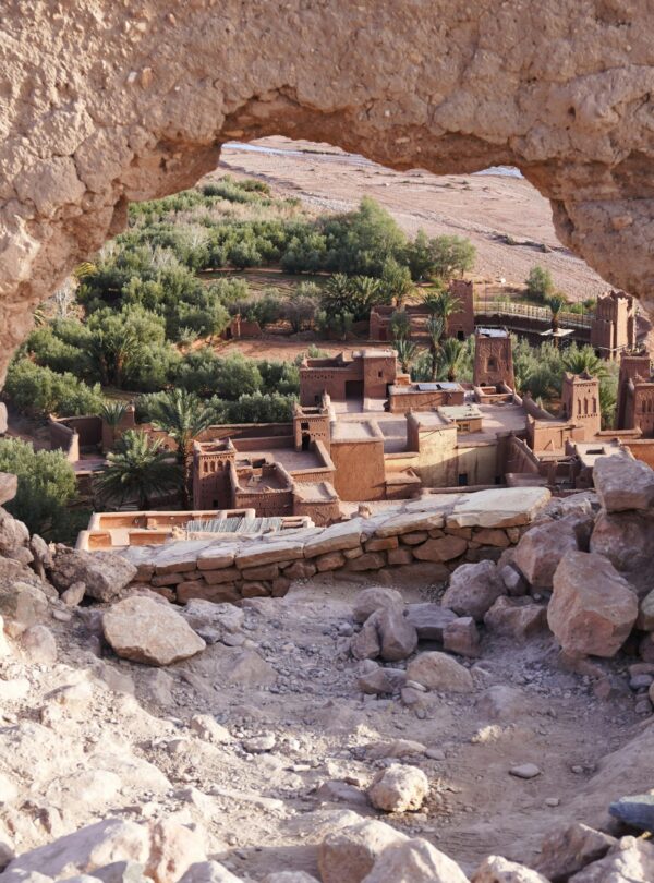 A picturesque view of Aït-Ben-Haddou through ancient ruins, showcasing Morocco's desert architecture.