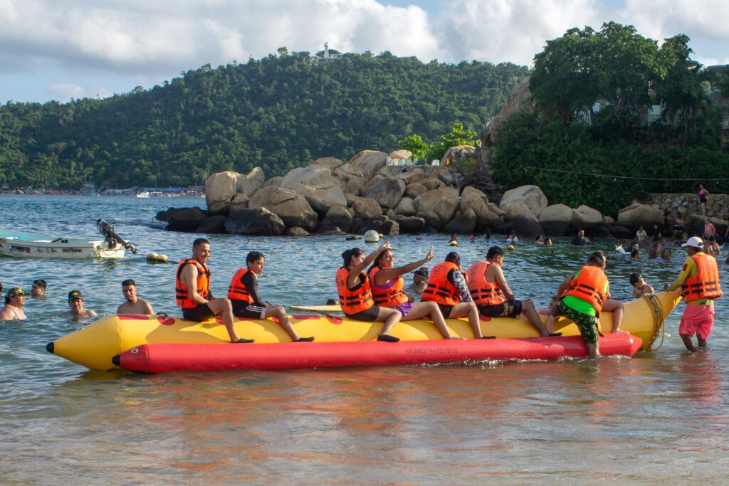 Group enjoying a thrilling banana boat ride at Acapulco beach under the sun.
