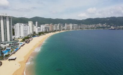 Scenic aerial shot of Acapulco Bay with beachfront resorts and coastline.