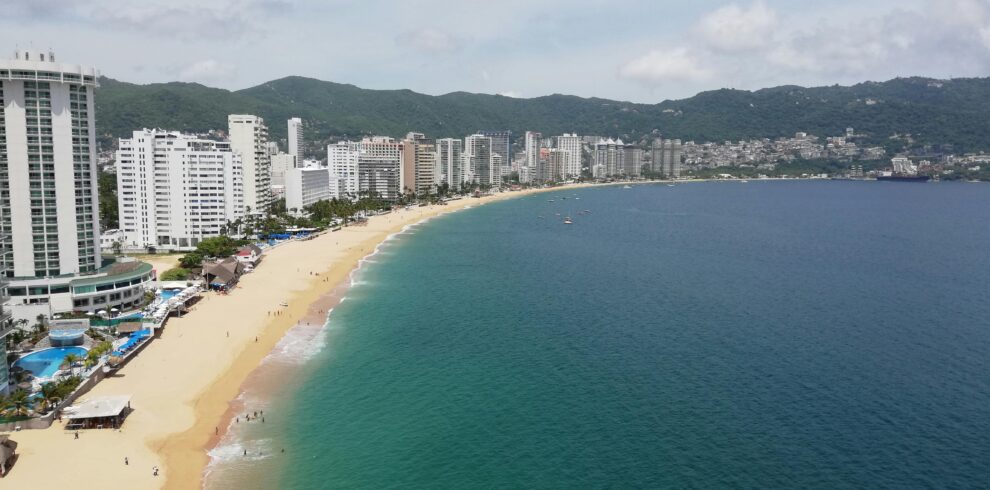 Scenic aerial shot of Acapulco Bay with beachfront resorts and coastline.