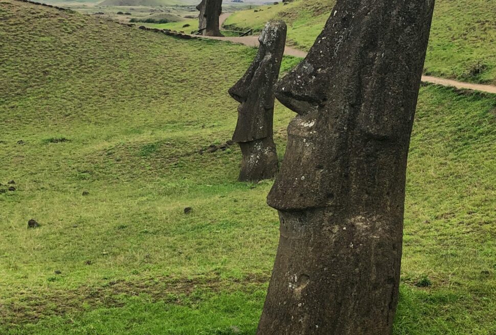 Moai statues on Easter Island, iconic Rapa Nui megaliths in a lush green setting.
